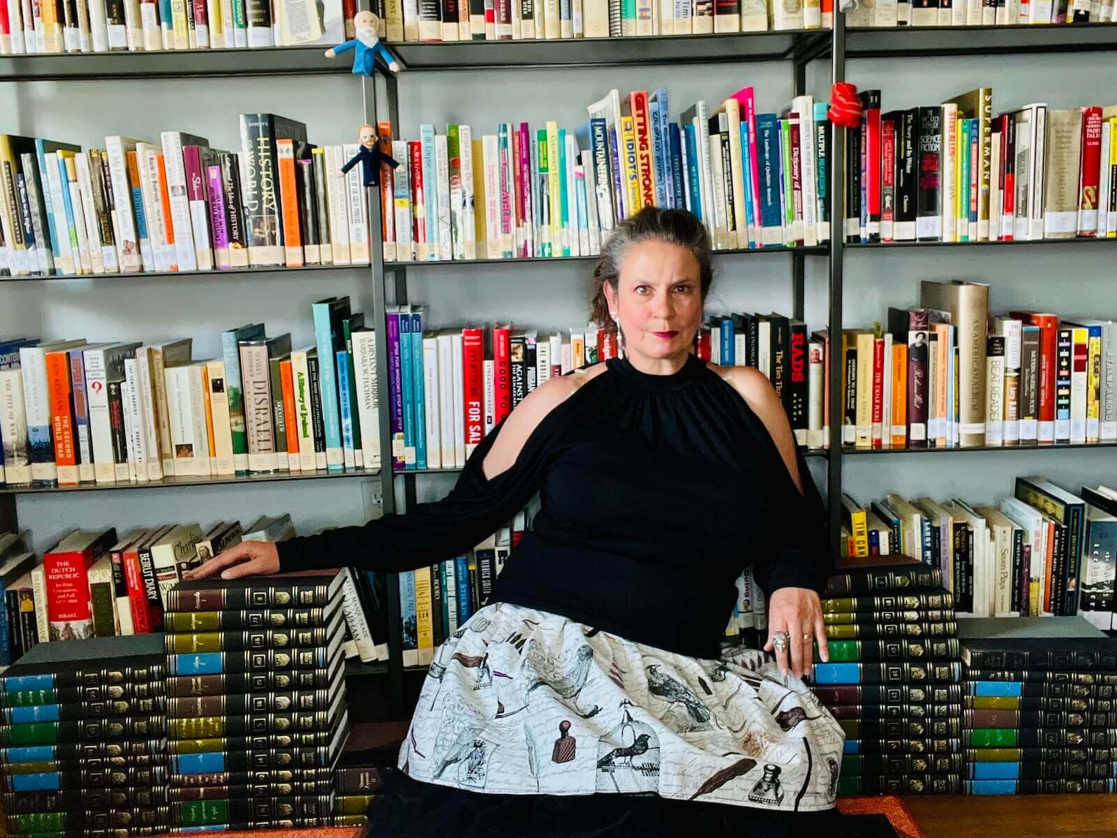 Carolyn in front of shelves of books.